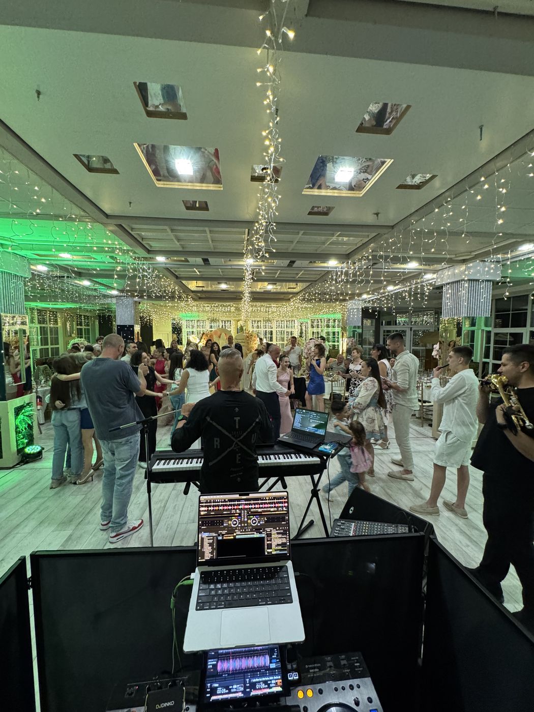 DJ пулт с клавир и гости на дансинга със зелено осветление